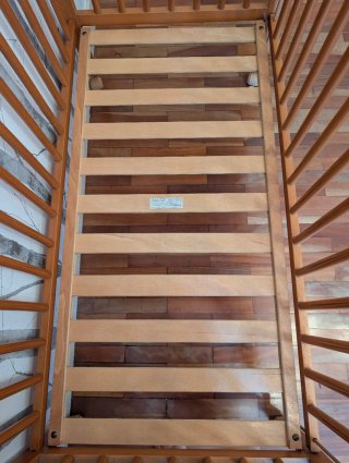 Cuna de madera para bebé con ositos grabados.