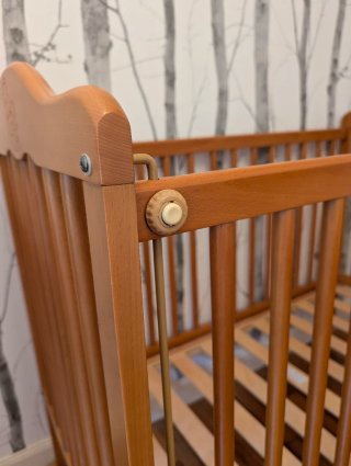 Cuna de madera para bebé con ositos grabados.