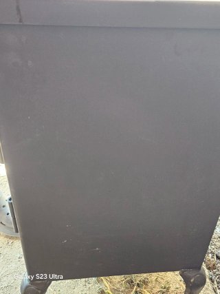 Estufa de leña negra con puerta de cristal