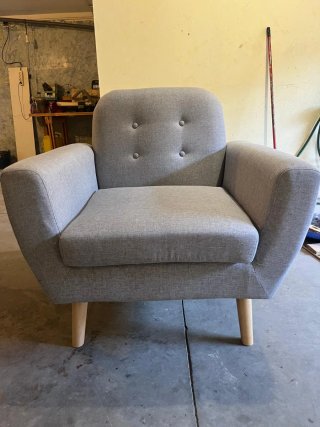 Sillón gris, patas de madera.