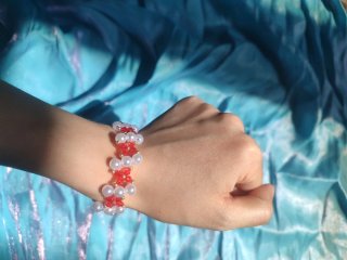 Pulsera artesanal de flores rojas y perlas blancas