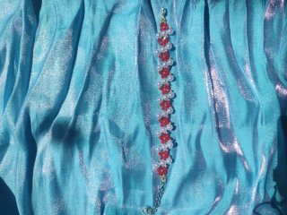 Pulsera artesanal de flores rojas y perlas blancas