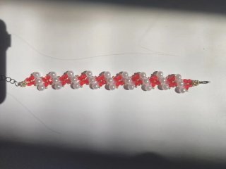 Pulsera artesanal de flores rojas y perlas blancas