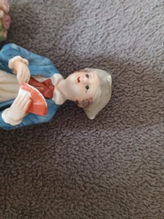 Muñeco de porcelana sentado en banco