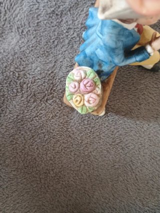Muñeco de porcelana sentado en banco