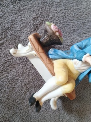 Muñeco de porcelana sentado en banco