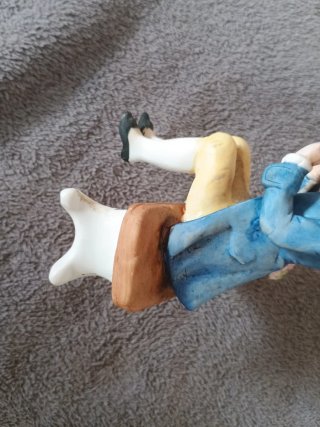 Muñeco de porcelana sentado en banco