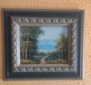 Cuadro al óleo con paisaje de lago y montañas