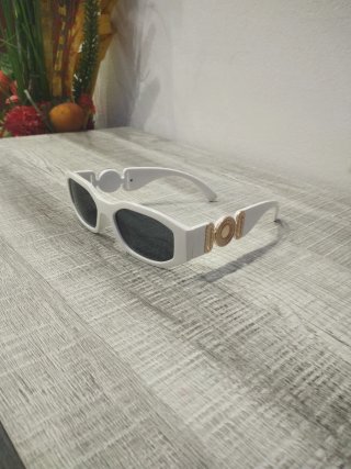 Gafas de sol blancas y negras con detalle dorado.