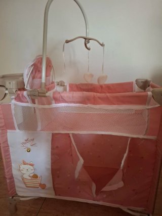Cuna de muñeca rosa con móvil
