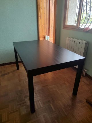 Mesa de comedor oscura con vetas.