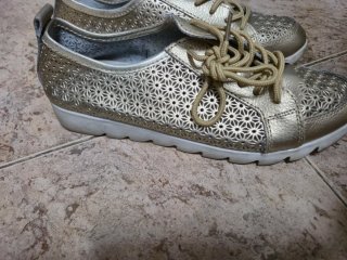 Zapatos dorados con cordones y diseño calado