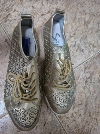 Zapatos dorados con cordones y diseño calado