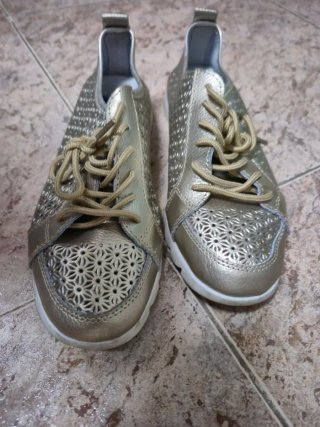 Zapatos dorados con cordones y diseño calado