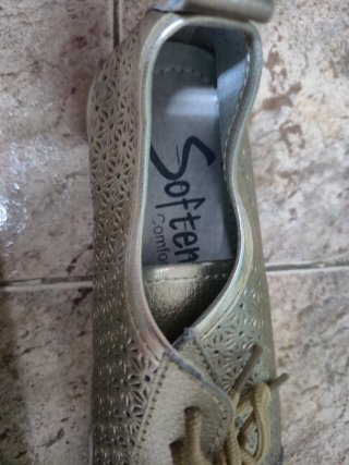 Zapatos dorados con cordones y diseño calado
