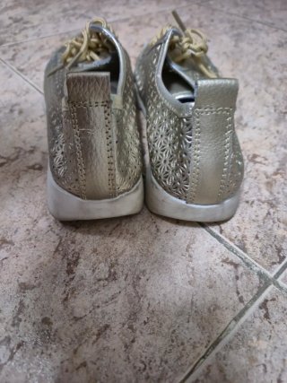 Zapatos dorados con cordones y diseño calado