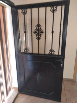 Puerta de hierro con reja y cristal
