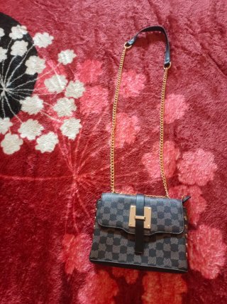 Bolso negro y dorado con cadena