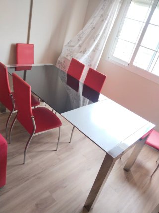 Mesa de cristal con 6 sillas rojas