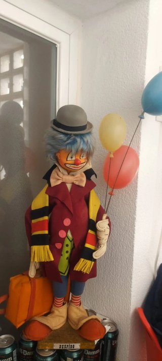 Figura vintage di pagliaccio con palloncini e valigia
