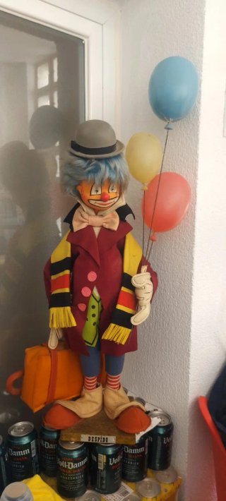 Figura vintage di pagliaccio con palloncini e valigia