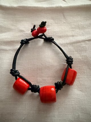 Pulsera con cuentas rojas y cordón negro