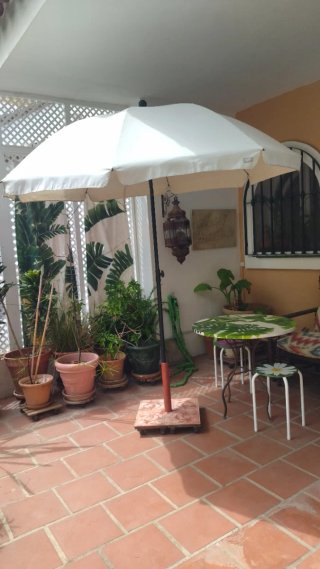 Sombrilla beige con pie de hierro