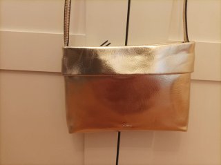 Bolso dorado tipo sobre con correa