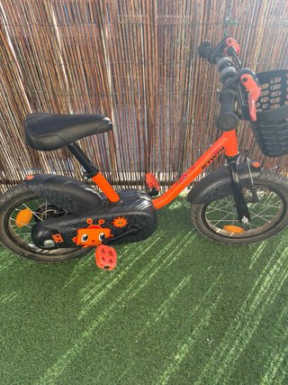 Bicicleta infantil naranja con cesta