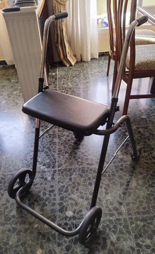 Andador con asiento y ruedas.