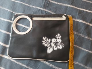 Bolso de mano negro con flores blancas