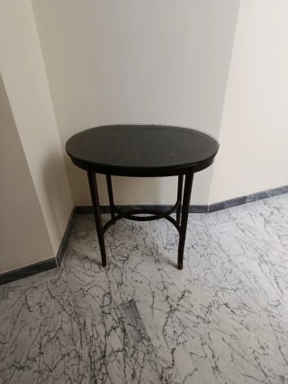Mesa ovalada antigua de madera con cristal.