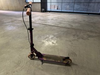 Patinete morado con ruedas naranjas