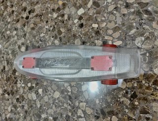 Monopatín transparente con ruedas rojas