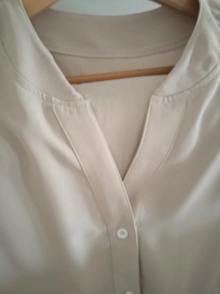 Blusa beige con cinturón.