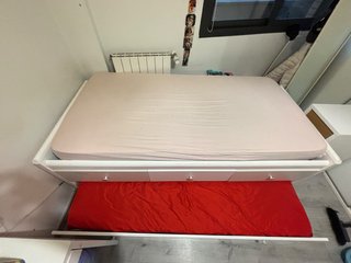 Cama nido con colchón beige y blanco.
