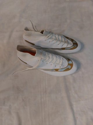 Zapatillas deportivas blancas y doradas