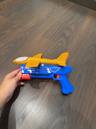 Pistola de juguete con avión naranja