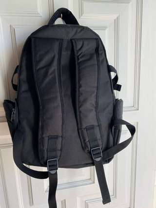 Mochila negra con parche de cuadros