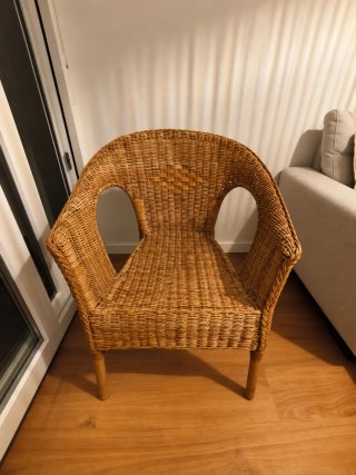 Sillón de mimbre con cojín blanco
