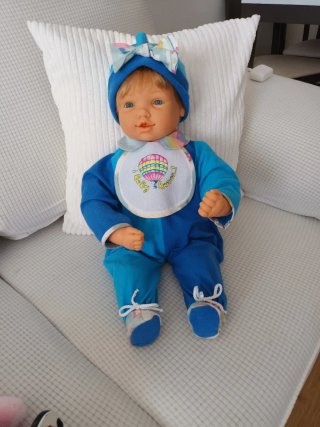 Muñeco bebé con traje azul y babero