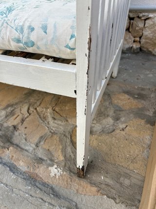 Banco de madera blanco con cojines florales