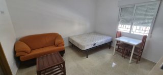 Habitación tipo loft con cocina y baño privado.