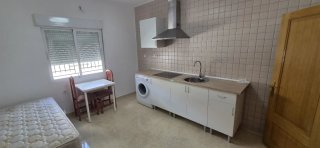 Habitación tipo loft con cocina y baño privado.