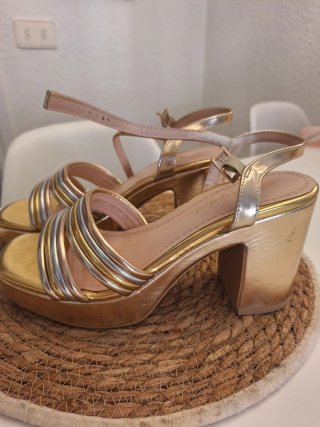 Sandalias doradas de fiesta.