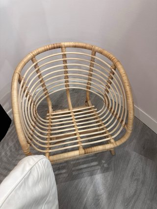 Sillón de ratán con cojín blanco