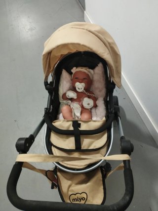 Carrito de bebé color beige y negro con bebé