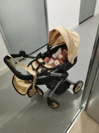 Carrito de bebé color beige y negro con bebé
