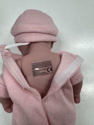 Muñeca bebé rosa con gorrito y calcetines