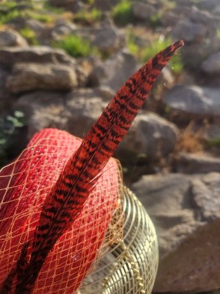 Casquete naranja con velo y pluma